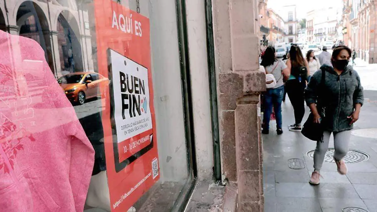 mujer pasa por una tienda con promoción del Buen fin en el centro de Zacatecas